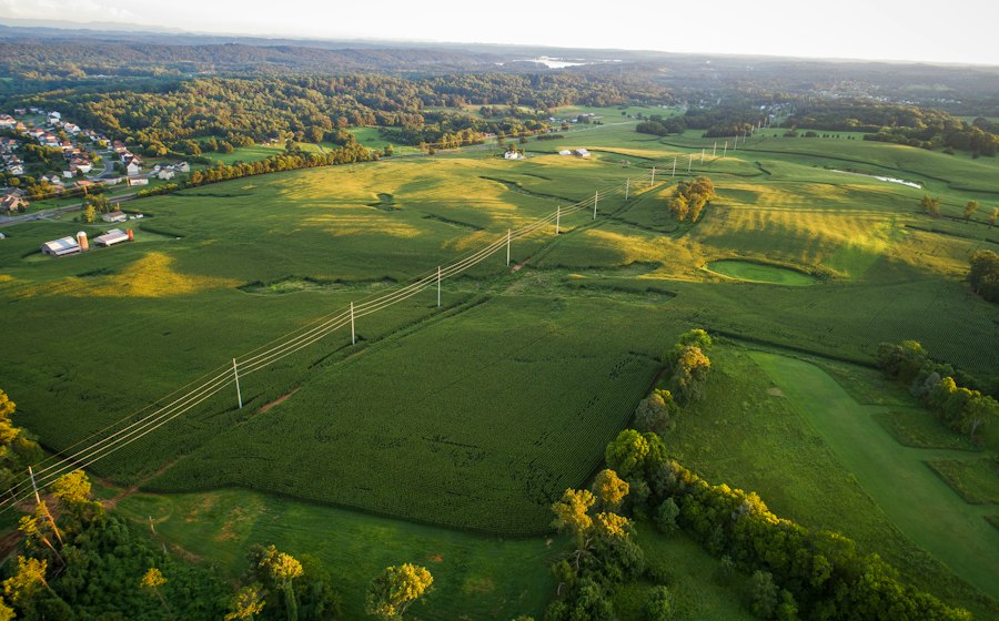Power lines crossing open land beside a small town