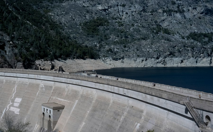 A concrete dam holding back a mountain reservoir